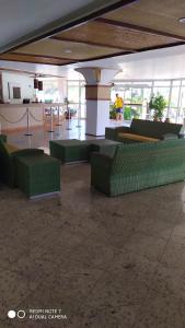 una habitación con sillas y mesas verdes en un edificio en Gran Lençóis Flat Residence Barreirinhas - Mandacaru 211, en Barreirinhas