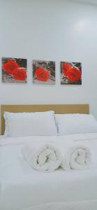 un letto con rose rosse sopra con tre foto di Cozy Corner House #4 Bedroom #3 Bathroom a Ipoh