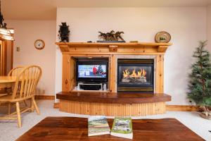 ein Wohnzimmer mit einem Kamin und einem TV in der Unterkunft Targhee Rentals 414 Teton Creek Resort Driggs ID in Driggs