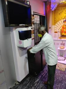 Un uomo sta in piedi in una stanza con la televisione di Hotel Sai Guest House a Nagpur