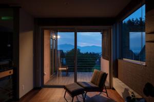 a room with a large window with a view of the mountains at MOKUREN in Furano