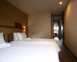 Habitación de hotel con 2 camas y pasillo en MOKUREN, en Furano