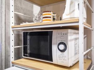 a microwave oven on a shelf in a kitchen at Little Island Okinawa Nago in Nago