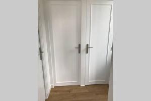 an empty room with white doors and a wooden floor at le Nicole in Chartres