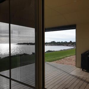 Pokój z widokiem na jezioro przez szklane drzwi w obiekcie Blue Seas - Beach Front Living w mieście Tumby Bay