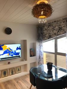 Una sala de estar con una mesa y un televisor. en LA MER, en La Grande-Motte