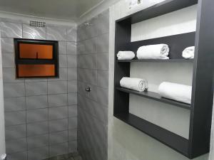 Cape Town的住宿－ANNEX LODGE & SPa，浴室配有黑色架子和白色毛巾
