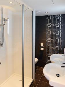 a bathroom with a shower, sink, and toilet at Amrâth Hotel DuCasque in Maastricht