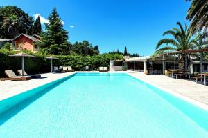 a large swimming pool with blue water in a yard at Anita in Perama