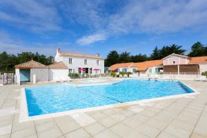 ein großer Pool in einem Hof mit einem Haus in der Unterkunft Madame Vacances les Mas de Saint Hilaire in Saint-Hilaire-de-Riez