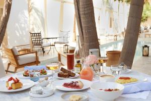 a table with plates of food and glasses of wine at Cara Hotel in Los Angeles