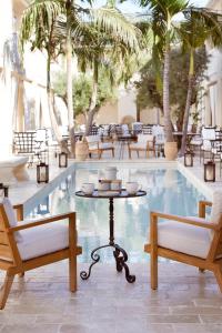a pool with two chairs and a table in front of it at Cara Hotel in Los Angeles