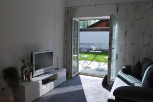 salon z telewizorem i kanapą w obiekcie Ruheoase am Forggensee w mieście Rieden