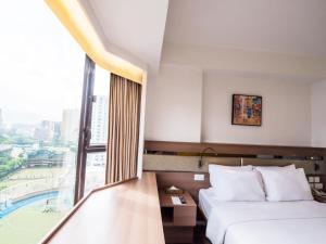 a hotel room with two beds and a large window at Travelodge Kowloon in Hong Kong