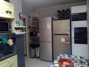 eine Küche mit zwei Kühlschränken und einem Tisch darin in der Unterkunft L'auberge des travailleurs in Échirolles