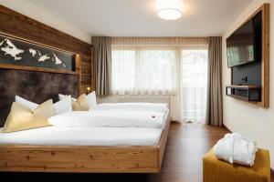 a hotel room with two beds and a television at Apart Garni Hax'n Tenne in Serfaus