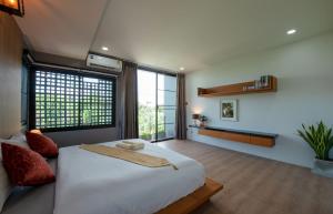ein Schlafzimmer mit einem großen Bett und einem großen Fenster in der Unterkunft Areya Villa in Chiang Mai