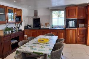 a kitchen with a table with chairs and a kitchen with a counter at VILLA LORET in Étang-Salé