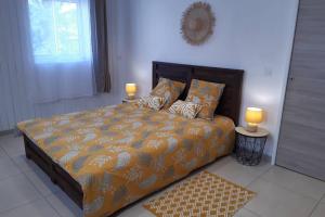 a bedroom with a bed with two lamps on it at VILLA LORET in Étang-Salé