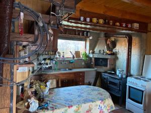 uma pequena cozinha com uma mesa e um fogão em Ранчо Бандера em Tsŭrvenyano