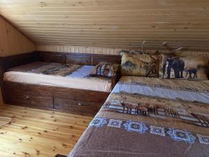 Duas camas num quarto com pisos em madeira em Ранчо Бандера em Tsŭrvenyano