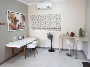 a white room with a table and chairs and a fan at Dunton Guest House in Johannesburg