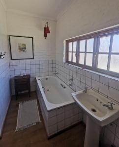 uma casa de banho com 2 lavatórios e uma banheira em Critchley Hackle Dullstroom Leisure em Dullstroom