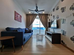 a living room with a blue couch and a ceiling fan at Thermospace The Wave B-13A-13 Melaka City in Melaka