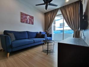 uma sala de estar com um sofá azul e uma ventoinha de tecto em Thermospace The Wave B-13A-13 Melaka City em Malaca