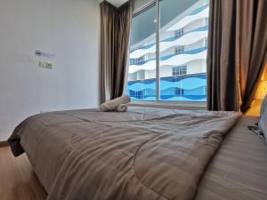 een groot bed in een slaapkamer met een groot raam bij Thermospace The Wave B-13A-13 Melaka City in Melaka