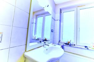 uma casa de banho branca com um lavatório e um espelho em Automne em Bruxelas