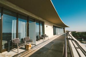 eine Reihe von Stühlen auf dem Balkon eines Gebäudes in der Unterkunft Even Derech by Smart Hotels in Mitzpe Ramon