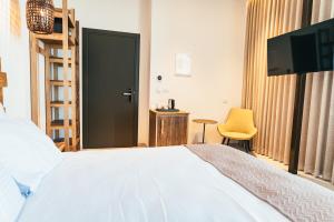 a bedroom with a bed and a tv and a chair at Even Derech by Smart Hotels in Mitzpe Ramon
