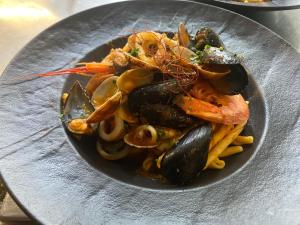 a bowl of pasta with mussels and vegetables on a table at Impero Hotel Beauty & Spa - Bike Hotel in Cantello