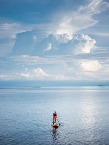 a man on a paddle board in the water at Rocky's Boutique Resort - Veranda Collection Samui in Lamai