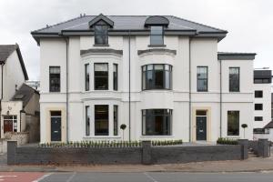 a white house with a black roof at Park Lane Aparthotel by Urban Space in Cardiff