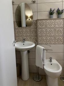 bagno con lavandino, servizi igienici e specchio di Kitezone beach Gizzeria a La Taverna