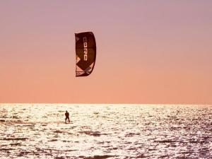 una persona sull'oceano che fa volare un aquilone di Kitezone beach Gizzeria a La Taverna