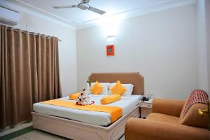 a bedroom with a bed and two chairs in it at Toshali Sands Puri in Puri