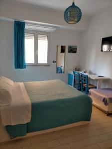 1 dormitorio con cama, mesa y cocina en ControVento Rooms en Margherita di Savoia