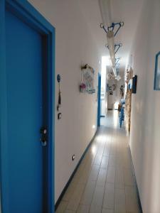 corridoio con porta blu e pavimento piastrellato di ControVento Rooms a Margherita di Savoia