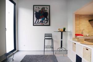 a kitchen with a stool and a painting on the wall at Minima Residence in Jakarta