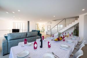a dining room with a long table and a blue couch at Villa Charlotte by Algarve Vacation in Armação de Pêra +42 photos