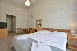 a hotel room with a bed with towels on it at Muza in Duszniki Zdrój