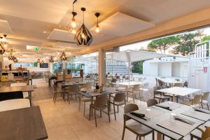 un ristorante con tavoli, sedie e finestre di Park Gallanti a Lido di Pomposa