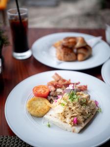two white plates of food on a wooden table at Rocky's Boutique Resort - Veranda Collection Samui in Lamai