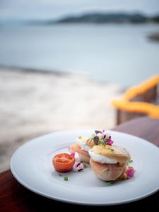 a white plate with food on a table at Rocky's Boutique Resort - Veranda Collection Samui in Lamai