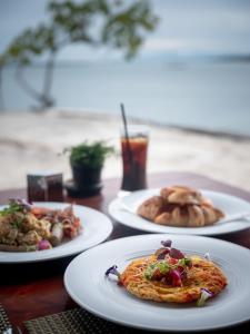 three plates of food on a wooden table at Rocky's Boutique Resort - Veranda Collection Samui in Lamai