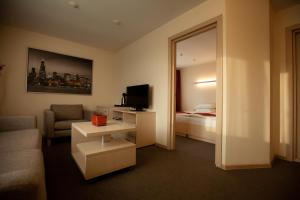 une chambre d'hôtel avec un canapé, un lit et un miroir dans l'établissement Uyut Centralnaya Hotel, à Klintsy