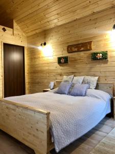 a bedroom with a bed in a wooden wall at Domeniul Horj Casa din Deal Moisei in Moisei